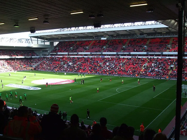Bên trong sân vận động Anfield với khán đài và mặt sân xanh mướt, sẵn sàng cho trận đấu