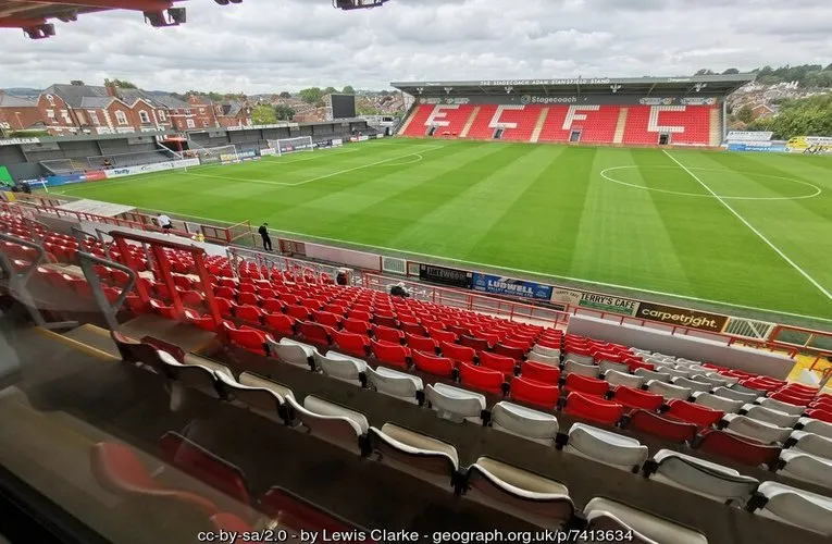 Góc nhìn toàn cảnh sân bóng St. James Park Exeter từ trên khán đài, nơi các cầu thủ Exeter City trình diễn tài năng