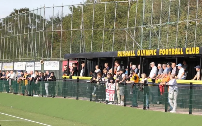 Khu khán đài đứng mộc mạc tại sân Dales Lane, nơi các cổ động viên Rushall Olympic FC chia sẻ từng cung bậc cảm xúc của trận đấu, thể hiện sự gần gũi và chân thực của bóng đá địa phương.