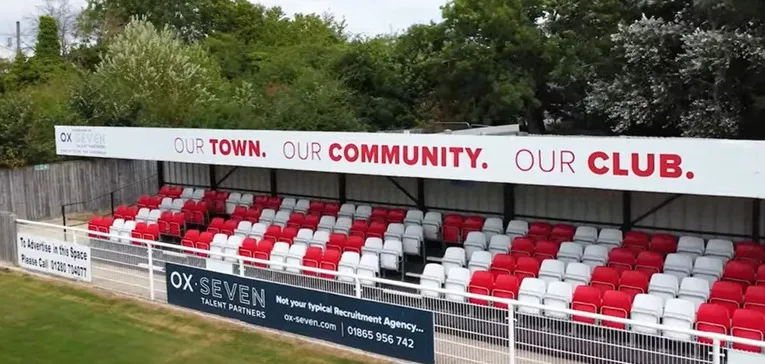 Khu vực khán đài có mái che tại sân St James Park Brackley, nơi cổ động viên tìm chỗ trú mưa