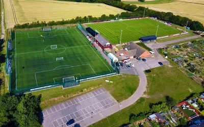 Sân vận động Bloomfields Needham Market nhìn từ trên cao, thể hiện kiến trúc đặc trưng của một sân bóng đá hạng thấp tại Anh.