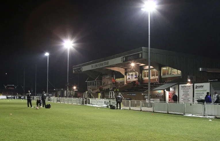 Sân vận động Hayes Lane lung linh trong ánh đèn đêm, nơi diễn ra các trận cầu hấp dẫn của Bromley FC