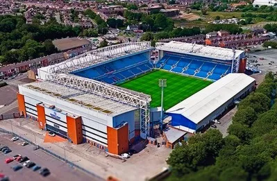 Toàn cảnh sân vận động Ewood Park từ trên cao, mái vòm và các khán đài xanh thẫm dưới ánh nắng.